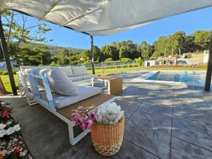 a bench under a white umbrella next to a pool at Villa Playa Covelo in Pontevedra