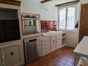 a kitchen with white cabinets and a sink and a window at Clair de Provence in Entrevennes