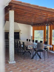 a dining room with a long table and chairs at Villa Playa Covelo in Pontevedra