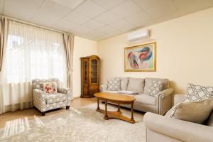 a living room with a couch and two chairs and a table at Tudor Central House Sibiu - Garden, Parking, Quiet Area in Sibiu