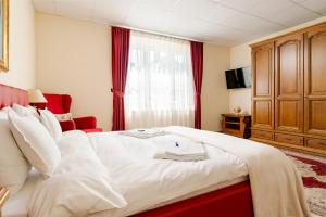 a hotel room with a bed with two towels on it at Tudor Central House Sibiu - Garden, Parking, Quiet Area in Sibiu