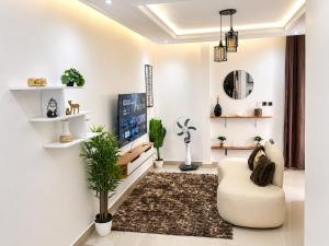 a living room with a couch and a tv at Skyline Residence Apartment in Douala in Douala