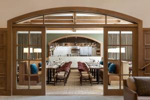 a dining room with tables and chairs and a large doorway at The Rusty Parrot Lodge and Spa in Jackson