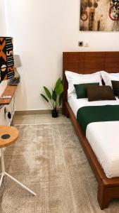 a bedroom with a large bed and a table at Skyline Residence Apartment in Douala in Douala