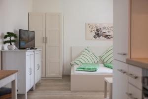 a white living room with a couch and a tv at Haus am Bach in Fulpmes