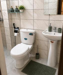 a bathroom with a toilet and a sink at Skyline Residence Apartment in Douala in Douala +13 photos