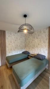 two beds in a room with a ceiling at Bagnole de l'Orne Studio in Bagnoles de l'Orne