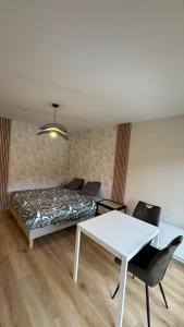 a bedroom with a bed and a white table at Bagnole de l'Orne Studio in Bagnoles de l'Orne