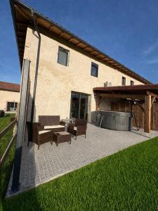 a patio with a table and chairs and a building at gite 8 pers avec SPA MARBOZ in Marboz