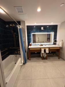 a bathroom with a tub and a sink and a mirror at Golden Mesa Hotel in Guymon +13 photos