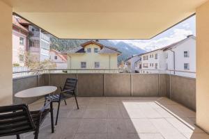 a balcony with a table and chairs and a view at Haus am Bach in Fulpmes