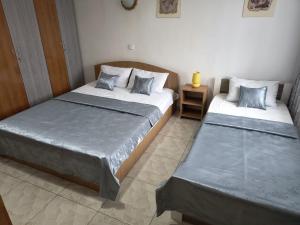 a bedroom with two beds and a night stand at Casa Dorului in Mangalia