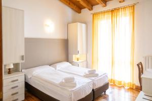 a bedroom with a bed with white sheets and a window at Appartamenti Apollo XI, GTSGroup in Tignale