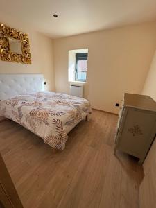 a bedroom with a bed and a dresser in it at gite 8 pers avec SPA MARBOZ in Marboz