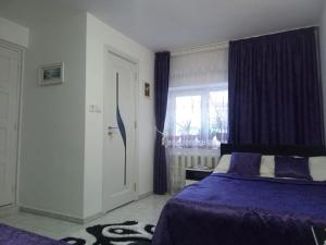 a bedroom with a purple bed and a window at Casa Dorului in Mangalia +8 photos