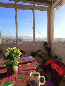 a table with a coffee cup on a table with a window at Casa Julia Xela in Quetzaltenango