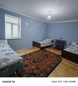 a room with two beds and a rug at Zaur Guest hause in Xınalıq
