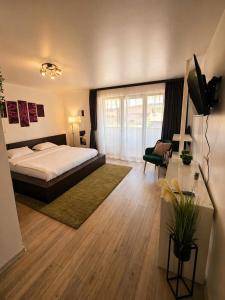 a bedroom with a bed and a desk with a television at Pensiunea Relax in Curtea de Argeş