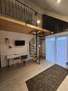 a living room with a loft bed and a desk at Pensiunea Relax in Curtea de Argeş