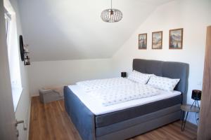a bedroom with a bed in a room with a chandelier at Auszeit im Weindorf in Kappelrodeck