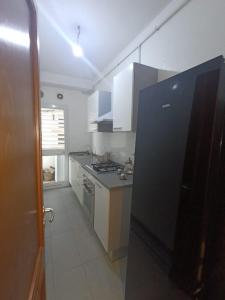 a kitchen with a black refrigerator in a room at Salem in Sidi Daoud