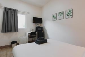 a bedroom with a white bed and a desk at Kavana Kata Residence in Phuket