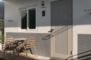 a patio with a table and chairs next to a door at Kavana Kata Residence in Phuket