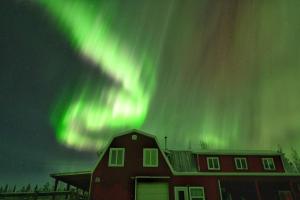 a house with a barn under the northern lights at The Big Red Barn in Whitehorse +11 photos