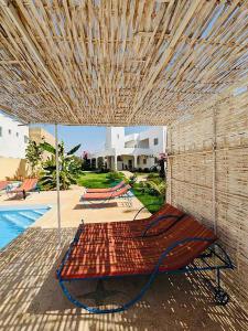 a porch with a swinging bed under a wooden ceiling at Villa Saraba in Somone