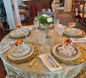 a table with plates and dishes on it with flowers at Steele Cottage in Vicksburg