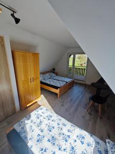 a attic bedroom with two beds and a window at Domek na Górce 2 in Krościenko