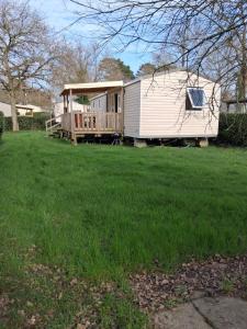 a mobile home with a porch and a deck at Mobil home 590 in Pont-Aven