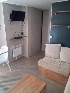 a living room with a couch and a tv at Mobil home 590 in Pont-Aven