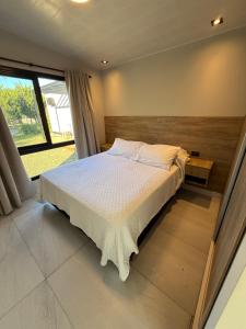 a bedroom with a bed and a large window at Casa María - Sanagasta in Villa Bustos