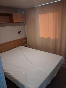 a bed in a small room with a window at Mobil home 590 in Pont-Aven