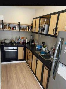 a kitchen with wooden cabinets and a black counter top at TutiFuti Casa in Chuy
