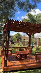 a wooden gazebo with a picnic table and benches at TutiFuti Casa in Chuy