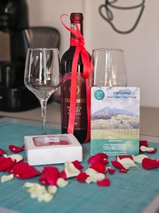 ein Tisch mit einem Weinglas und einer Flasche Wein in der Unterkunft Peak View Tiny House - Piatra Craiului Nest in Zărneşti