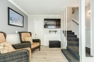 a living room with two chairs and a staircase at Beachfront - Private Walkover to Beach in Surfside Beach
