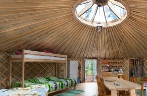 ein Zimmer mit Holzdecke, mit einem Bett und einem Tisch in der Unterkunft Yurtos in Gaugariai