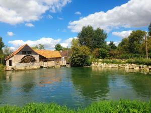 a river with a building on the side of it at Longère 'Nature et Baies' in Montigny