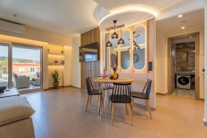 a dining room and living room with a table and chairs at The Mall Luxury Suites in Nikiti