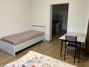 a room with two beds and a desk and a table at Don Kichot in Grajewo