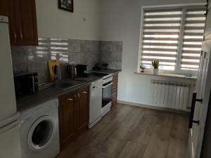a kitchen with a washing machine and a washer at Don Kichot in Grajewo