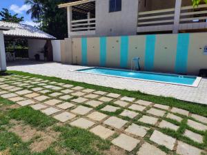 a swimming pool in a yard next to a building at Refúgio Guarajuba, 50m da Praia, Piscina, Recarga EV, área gourmet, churrasqueira in Camaçari +46 photos