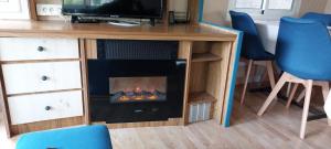 a fireplace in a desk with chairs and a television at Mobile home style maisonnette de vacance in Méjannes-le-Clap