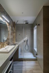 a bathroom with a shower and a sink and a tub at The Mall Luxury Suites in Nikiti +95 photos