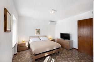 a bedroom with a bed and a flat screen tv at Ca' Due Cuori in Torri del Benaco