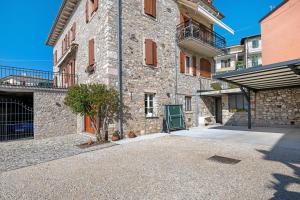 a stone building with a green door in a courtyard at Ca' Due Cuori in Torri del Benaco