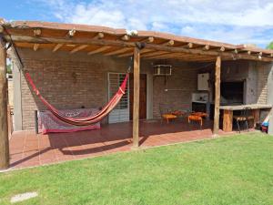a pergola with a hammock on a patio at Osvaldo Day Cabin with Pool in Albardón